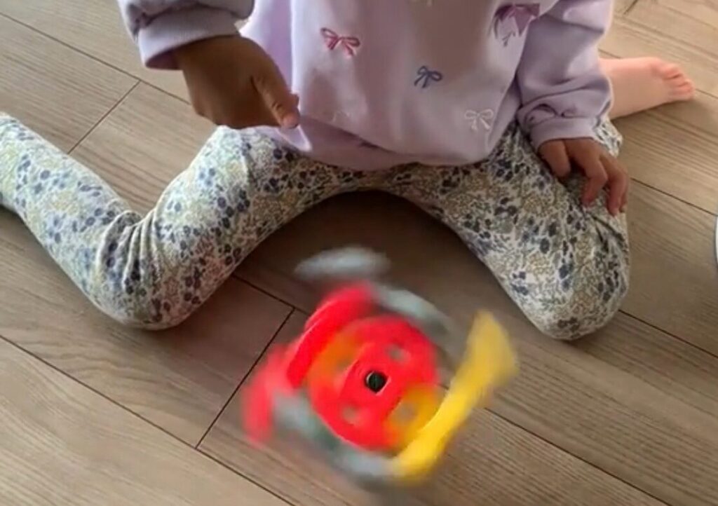 学研ニューブロックで作ったコマを床で回して遊ぶ娘